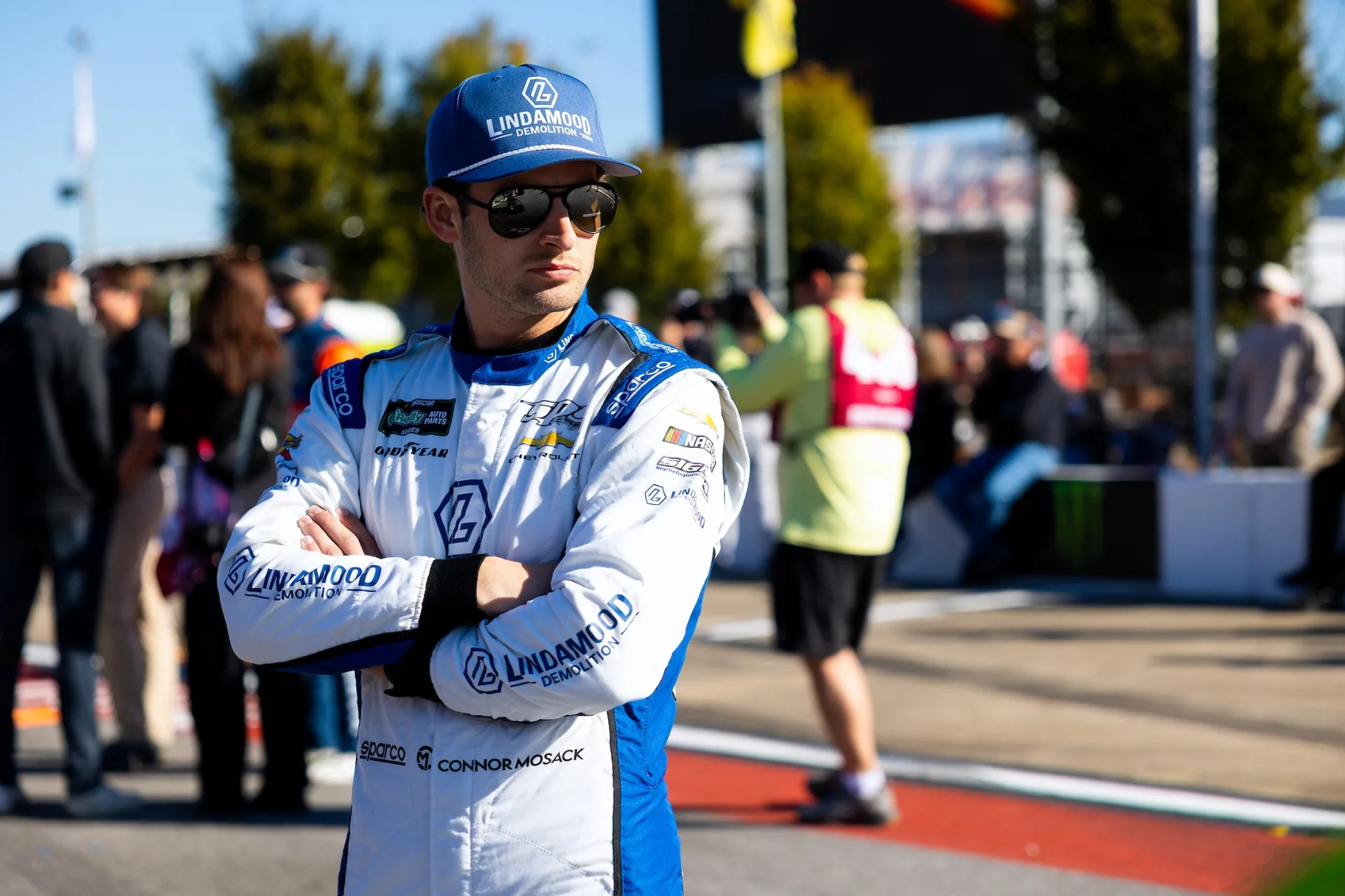 Connor Mosack stands with his arms crossed in his Lindamood racing suit at Talladega Superspeedway.